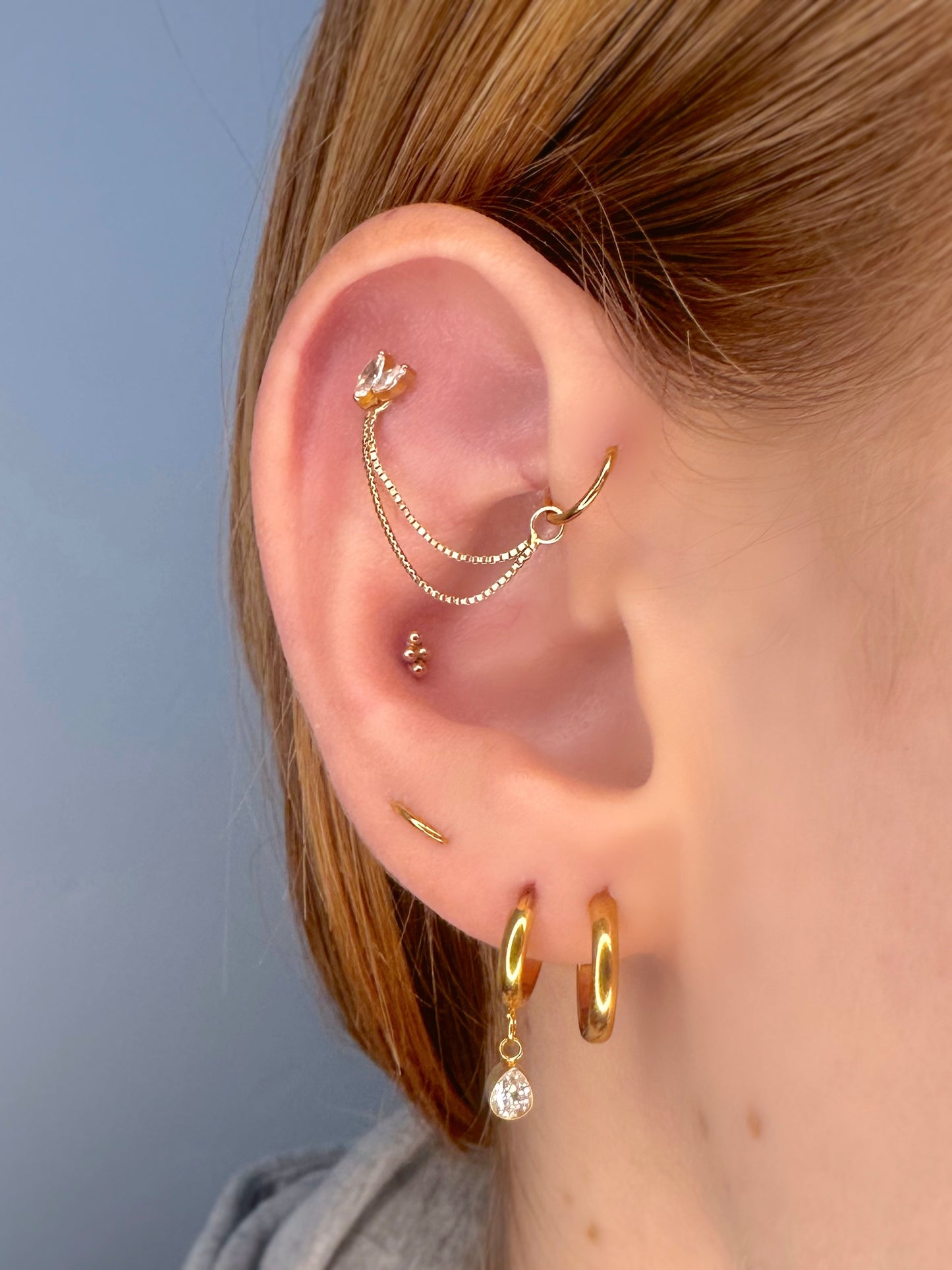 Close-up of an ear showing the earrings on a real ear.